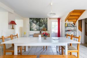 a dining room with a white table and chairs at La Savariere Gite campagne et plage pour 12 in Landevieille