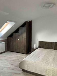 a bedroom with a large bed and wooden cabinets at Samadhi Aparthotel in Miercurea-Ciuc