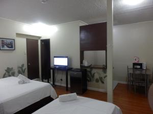 a hotel room with two beds and a television at Casa Saudade Condotels and Transient Rooms in Olongapo
