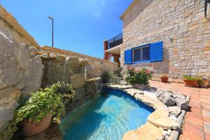 een zwembad aan de zijkant van een stenen gebouw bij Villa Antica in Drage +30 foto's