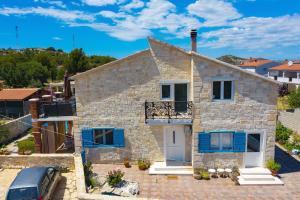 een stenen huis met blauwe luiken en een auto bij Villa Antica in Drage