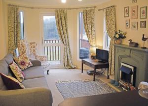 a living room with a couch and a fireplace at Clear Sky Lodge Park in Falstone