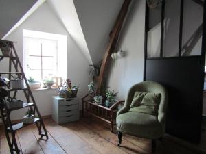 a living room with a chair and a window at chez LISON, HEBERGEMENT DE CHARME EN MADIRAN in Diusse +2 photos