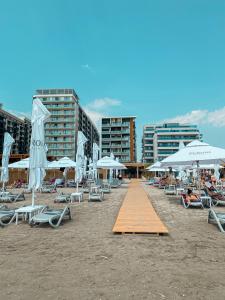 - une plage avec des chaises et des parasols dans l'établissement Black Sea Booking-London, à Mamaia Nord – Năvodari