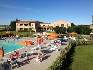 un gruppo di persone seduti intorno alla piscina in un resort di Residence Casale Torrenova al Conero a Potenza Picena
