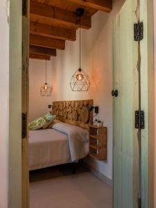 een slaapkamer met een bed en 2 hanglampen bij Alojamientos Biarritz VISTA JARDÍN in Fuenteheridos
