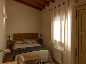 um quarto com uma cama e uma janela em Alojamientos Biarritz VISTA JARDÍN em Fuenteheridos