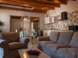 a living room with two couches and a kitchen at Alojamientos Biarritz VISTA JARDÍN in Fuenteheridos