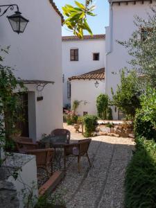 a courtyard with a table and chairs in a building at Alojamientos Biarritz VISTA JARDÍN in Fuenteheridos