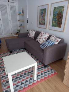 a living room with a couch and a table at Las Canteras Sunset Beachfront in Las Palmas de Gran Canaria