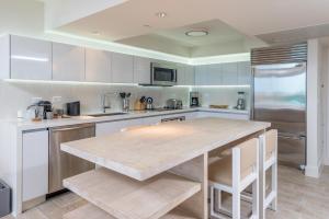 a kitchen with white cabinets and a large counter top at Luxurious Private Condo at 1 Hotel & Homes -1127 in Miami Beach