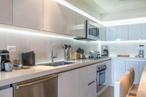 a kitchen with white cabinets and a sink at Luxurious Private Condo at 1 Hotel & Homes -1127 in Miami Beach