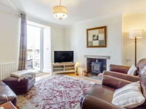 a living room with a couch and a fireplace at Sycamore Cottage in Matlock