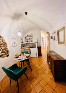 cocina con mesa y silla verde en Stecadó Casté - Nel centro storico del paese, en Dolceacqua