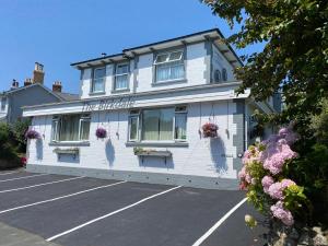 a white building with flowers in a parking lot at Birkdale Guest House in Shanklin
