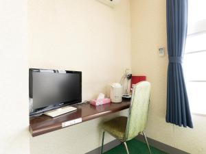 a room with a desk with a tv and a chair at Tabist Business Hotel Chitose Kashiwazaki in Kashiwazaki