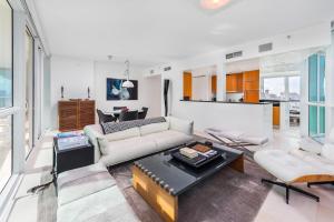 uma sala de estar com um sofá e uma mesa em Oceanfront Private Condo at The Setai -2208 em Miami Beach