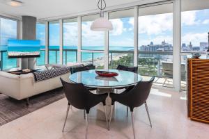 uma sala de estar com uma mesa e um sofá em Oceanfront Private Condo at The Setai -2208 em Miami Beach