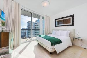 um quarto com uma cama e uma grande janela em Oceanfront Private Condo at The Setai -2208 em Miami Beach