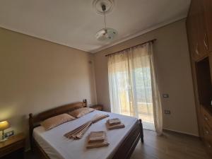 - une chambre avec un lit, des serviettes et une fenêtre dans l'établissement Welcome home, à Saranda