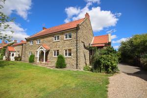 a large stone house with a red roof at The Horseshoe Country Inn in Pickering