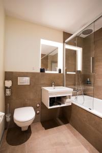 a bathroom with a toilet and a sink and a shower at Kreuz Bern Modern City Hotel in Bern