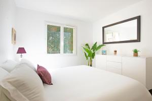ル・ラヴァンドゥーにあるSELECT'SO HOME - Résidence La Fossette - Terrasse vue mer - Prestations de qualité & Services Hôteliers - FOS-04の白いベッドルーム(白いベッド1台、鏡付)