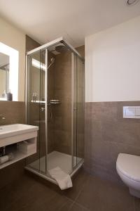 a bathroom with a glass shower and a sink at Kreuz Bern Modern City Hotel in Bern