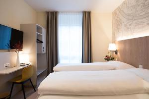 Postel nebo postele na pokoji v ubytování Kreuz Bern Modern City Hotel