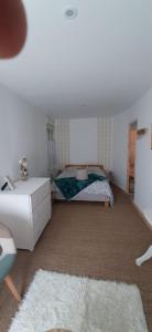 Schlafzimmer mit einem Bett, einer Kommode und einem Teppich in der Unterkunft Les chambres du Val d'Eyden 