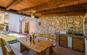 a dining room with a wooden table and a stone wall at 3 Bedroom Cozy Home In Vodnjan in Vodnjan