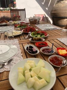 a wooden table with plates of food on it at annemin harabesi otel in Cesme