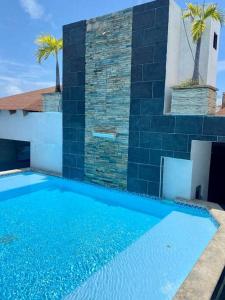 a large blue swimming pool in front of a house at New Condo Rooftop Pool. Gym. Discounted rate in Santo Domingo