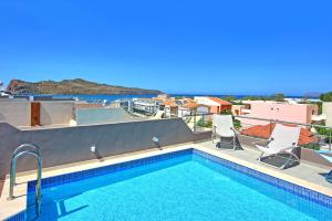 una piscina con sillas y vistas al océano en Cabanavillas Casablanca by PosarelliVillas, en Plaka