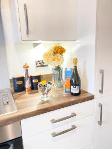 a kitchen counter with two bottles of wine and glasses at Tudors eSuites 3 Bed House Garden & Netflix in Birmingham