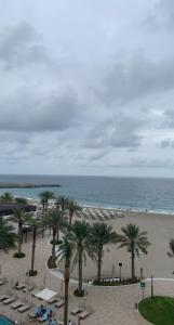 a view of a beach with palm trees and the ocean at luxury sea view Address Hotel apartment Fujairah in Fujairah