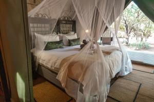 เตียงในห้องที่ Umkumbe Bush Lodge - Luxury Tented Camp