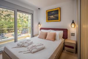 a bedroom with a bed with two towels on it at Villa Of the Hill with Heated Pool, BBQ & Kids Playground in Kavoúsion