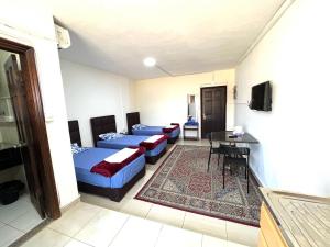een kamer met vier bedden en een tv. bij Al Qatal Building in Al Qasţal