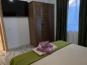 a bedroom with a bed with a flat screen tv at Casa Maria in 2 Mai