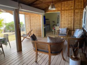 una veranda con tavolo e sedie su una terrazza di Villa Forbane en bord de plage a Saint-Gilles-les Bains