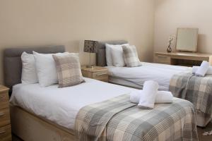 a bedroom with two beds with towels on them at The Haybarn in Wrexham