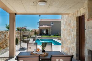 a patio with a table and chairs and a swimming pool at Luxury villa with pool,jacuzzi and sauna04 - by TA Leut Agency in Privlaka