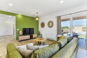 a living room with a large couch and a tv at Luxury villa with pool,jacuzzi and sauna04 - by TA Leut Agency in Privlaka