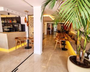 a restaurant with tables and chairs and a plant at S´Estancia Suites in Es Mercadal