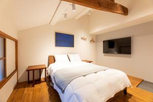 um quarto com uma cama grande e uma televisão em MACHIYA HOTEL madoka - Vacation STAY 65847v em Izumo
