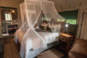 En eller flere senge i et værelse på Umkumbe Bush Lodge - Luxury Tented Camp