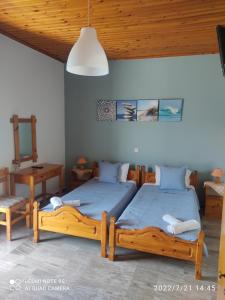a bedroom with two beds and a table and a lamp at Studios Maro in Skala Kallonis +21 photos