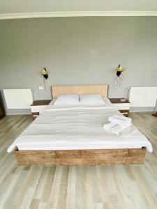 ein Schlafzimmer mit einem großen Bett mit weißer Bettwäsche in der Unterkunft Lia's Guest House in Sighnaghi