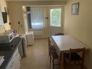 a kitchen with a table and chairs and a microwave at Gitta Apartmanház in Zalakaros